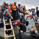 Asylum-seekers-and-migrants-descend-from-a-large-fishing-vessel-used-to-transport-them-from-Turkey-to-the-Greek-island-of-Lesbos.-October-11-2015.