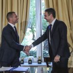 Greece’s Prime Minister Kyriakos Mitsotakis, right, shakes hands with UEFA President Aleskander Ceferin, during their meeting in Athens, Tuesday, Feb. 25, 2020.