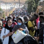 Refugees and migrants from the destroyed Moria camp wait to board busses to the port, from where they will be transferred to the mainland, on the island of Lesbos