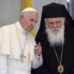 FILE PHOTO: Pope Francis gestures next to Archbishop Ieronymos II on the Greek Island of Lesbos