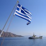 Greek flag blowing in the wind at sea