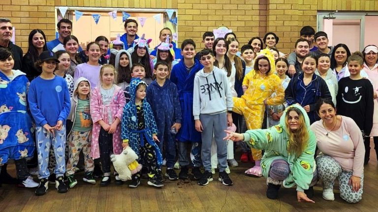 Pyjama-wearing members of the Cretan Association NSW raise funds for children in foster care