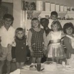 Amalia-Vosnakis-on-the-right-holding-the-little-girl.-Celebrating-a-cousins-birthday-1966