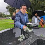 Deputy Mayor Lambros Tapinos scatters white flowers for the innocent victims.