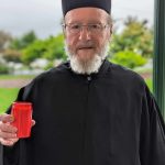 Fr Vasilios Kourtessis lit a candle of hope for the victims of genocide.
