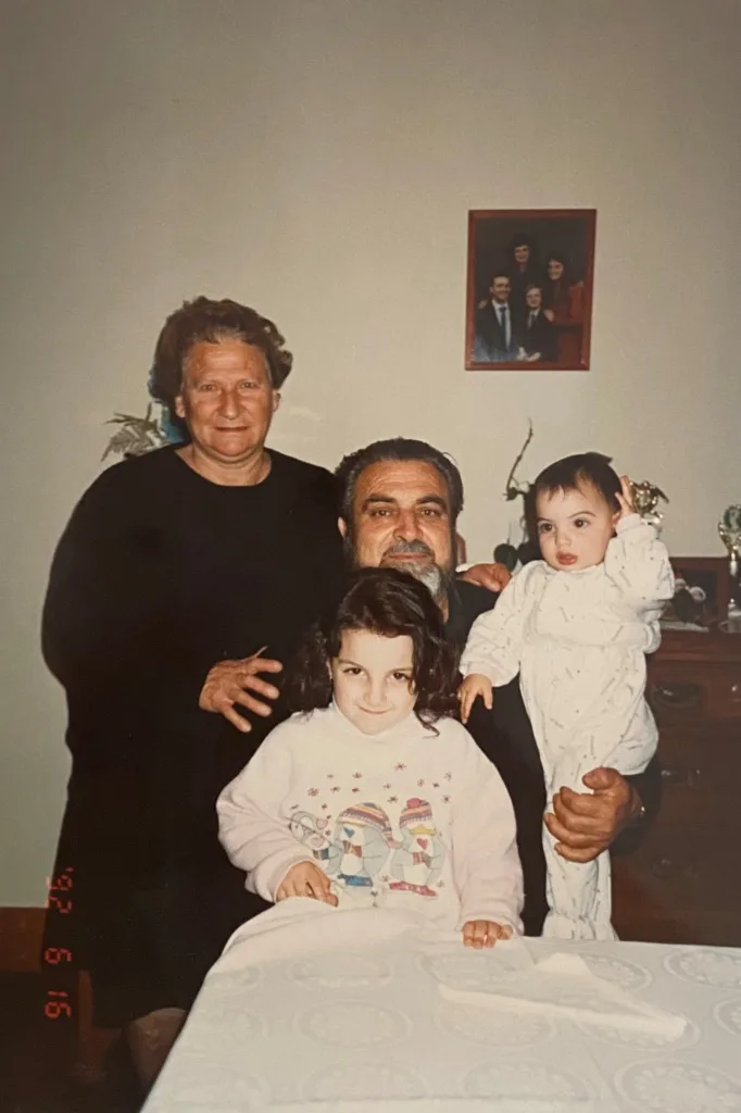 Presvitera and Father Charalambos holding Stephanie and her sister Myri.