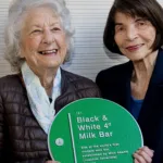 Mick Adams’ late daughters holding the Black & White Milk Bar plaque Martin Place, Sydney, 2020. Lilian Keldoulis (left) and Helen Gerondis. Photo by Effy Alexakis.