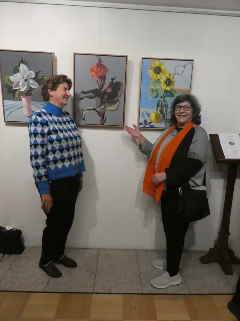 Left, Sophia Xeros-Konstantinides with her paintings and Ivy Cafici