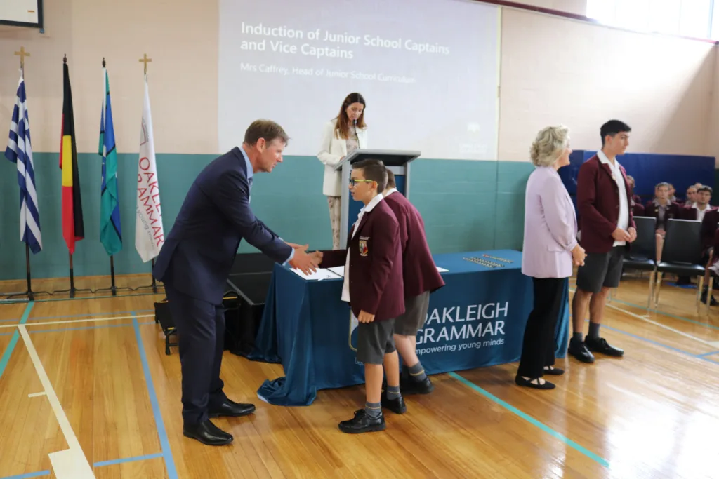 Principal Robertson congratulates a student leader