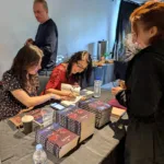 Koraly signs her book, ‘The Mother Must Die’, beside her daughter who created the illustration