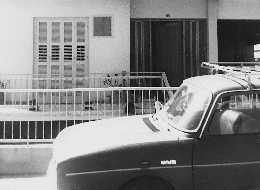 3.	Our little Renault in front of the duplex house where we lived in 1974. In the background on the right you can detect the opening of the unfinished side, where over 70 people sheltered the first night of the invasion, before fleeing for the mountains.