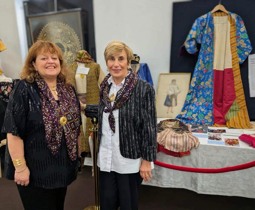 Gina Gekas and Christine Dimer infront of a garment heirloom worn by members of Dimer's family