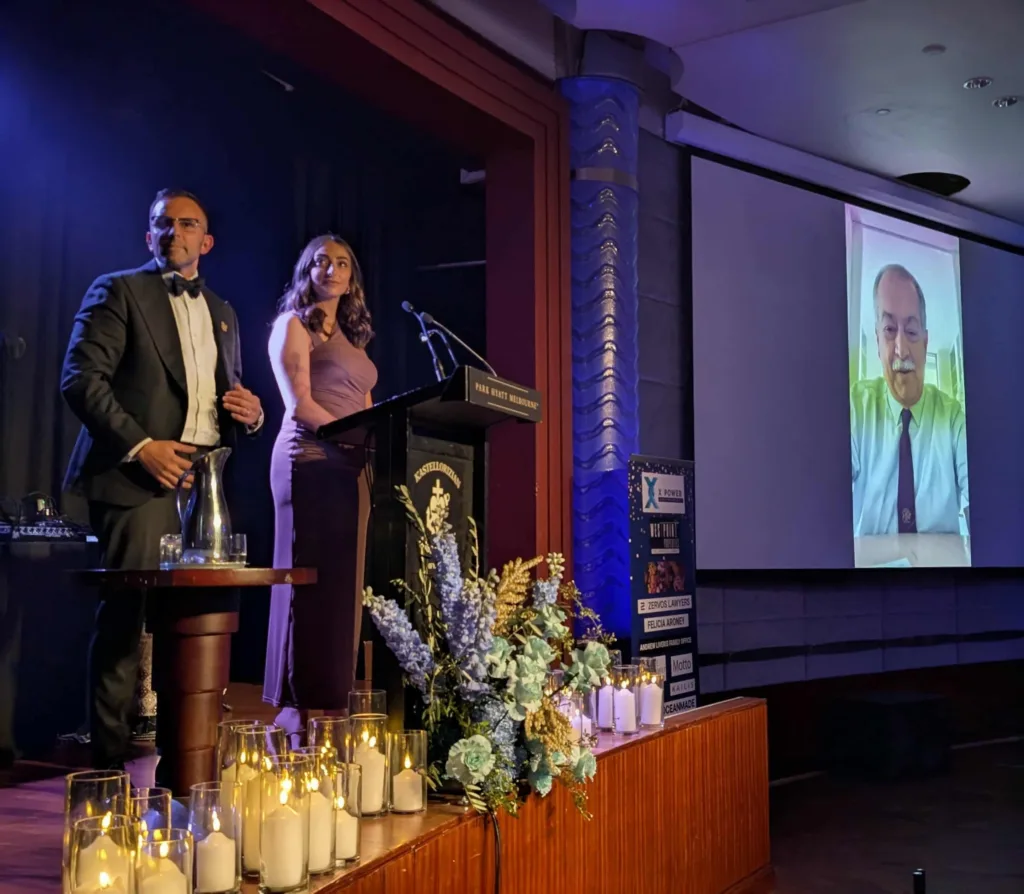 Stasi Agdemis and Kristin Vrahnas listen to a speech by Andrew Liveris