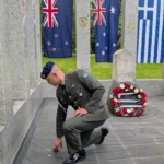 Captain Vasilios Athanasopoulos picks up a carnation