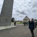 Dean Kaimakamis snaps a photograph behind the Eternal Flame