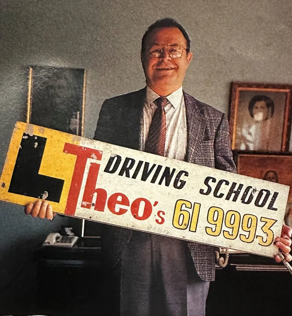 Theo Skalkos proudly held onto Theo’s Driving School signage. Photo by The Australian Magazine.