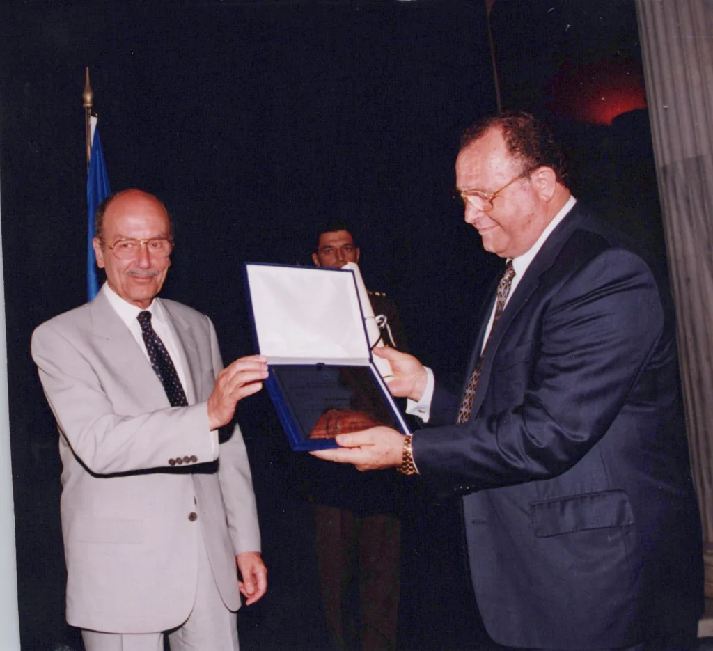 President Kostis Stephanopoulos presents Theo Skalkos with an international distinction awarded to The Greek Herald 1999