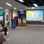 14. Attendees watch a video message from inductee Asimenia